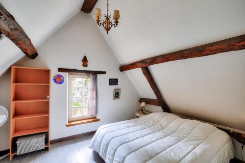 une chambre mansardée avec un lit et une fenêtre dans l'établissement Maison en pierre avec une terrasse, ideal pour 4, à Sarlat-la-Canéda
