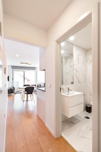 a white bathroom with a sink and a mirror at VIVA Bartolomeu Beach Flats in Porto