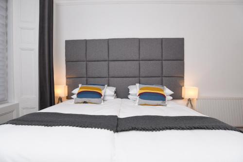 a bedroom with a large bed with a large headboard at City Base Apartment - Fast WiFi - Free Parking in Dundee