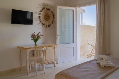 a room with a table and a desk with a window at Puloni in Otranto