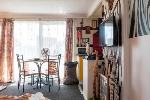 a dining room with a table and chairs and a window at Safari themed chalet in Great Yarmouth