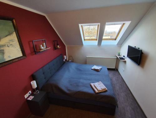 a small bedroom with a bed and a tv at GT Apartman in Dombóvár