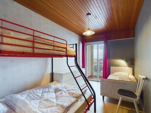 a bedroom with a bunk bed and a desk with a chair at Appartement pour 8 sur la Grande Plage de St Gilles in Le Sablais