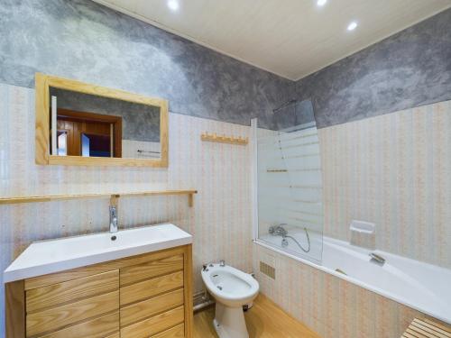 a bathroom with a sink and a toilet and a tub at Appartement pour 8 sur la Grande Plage de St Gilles in Le Sablais