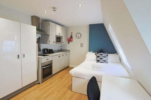 a small bedroom with a bed and a kitchen at Harford House studios 22 - Hopewell in Bristol