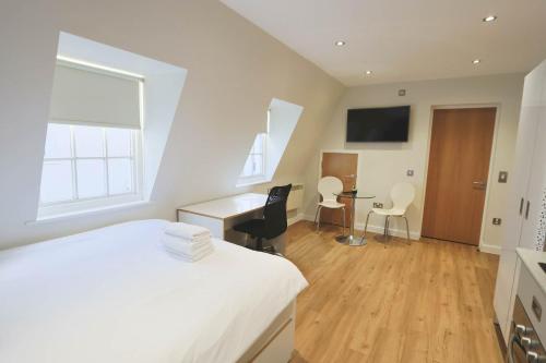 a bedroom with a bed and a desk with a computer at Harford House studios 22 - Hopewell in Bristol