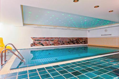 an indoor swimming pool with a large pool at Hotel Appartement Landhaus Stutzi - Hotel Strandperle in Cuxhaven