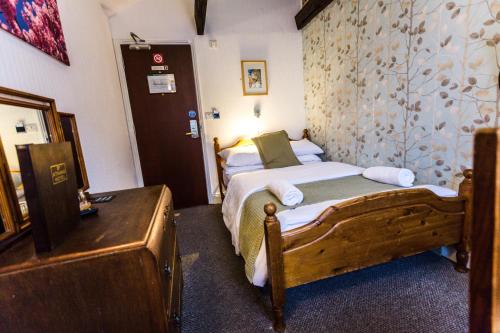 a bedroom with a wooden bed in a room at St Athans Hotel in London