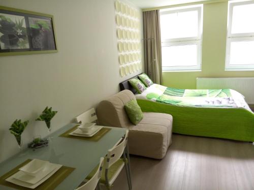 a small room with a green bed and a couch at Apartment Villa Ksenija in Ostend