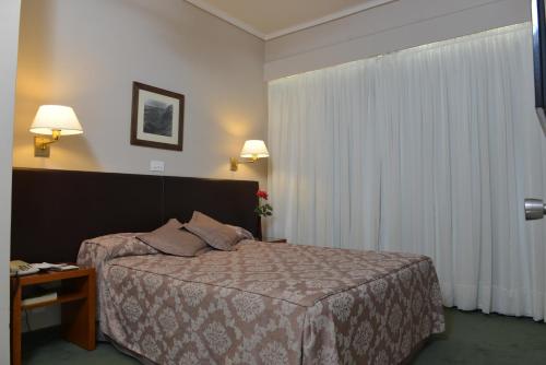 a hotel room with a bed and a window at Comodoro Hotel in Comodoro Rivadavia