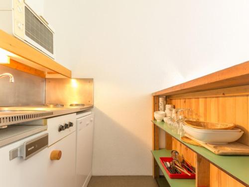 une cuisine avec des armoires blanches et un comptoir dans l'établissement Studio cabine · Balcon · Proche centre · WiFi gratuit - FR-1-346-508, à Arc 2000