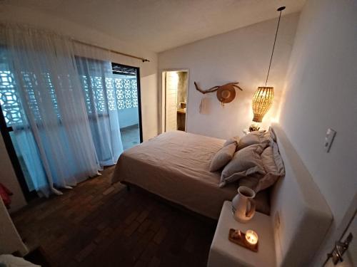 ein Schlafzimmer mit einem Bett und einer Lampe auf einem Tisch in der Unterkunft Occa Búzios in Nísia Floresta