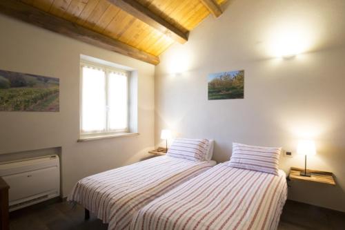 a bedroom with a bed with two pillows and a window at Ca'Rapulin in Calosso