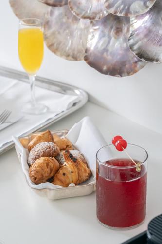 a table with a plate of pastries and a glass of juice at Hotel Belair in Sorrento
