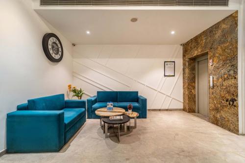 a living room with blue couches and a table at Treebo Premium The Mustard Inn Lawrence Road in Amritsar
