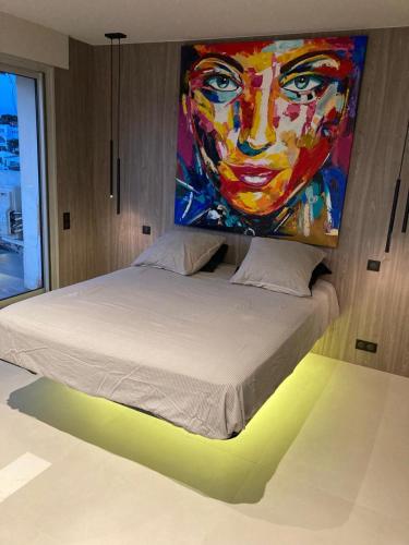 - un lit avec une peinture sur le mur au-dessus dans l'établissement TOP 3 pièces Juan Les Pins, à Antibes