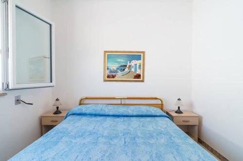 a bedroom with a blue bed and two night stands at Vista Mare Paradiso by Salento Prime in Torre Vado