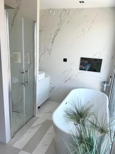 une salle de bain blanche avec une baignoire et une douche dans l'établissement TOP 3 pièces Juan Les Pins, à Antibes