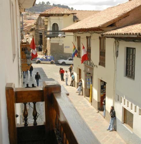 a group of people walking down a street in a town at Hostal & Apartments El Triunfo in Cusco