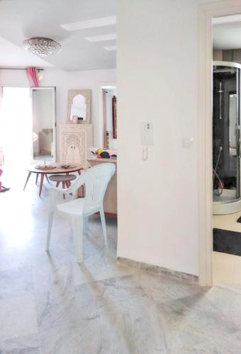 a dining room with a table and white chairs at Comfortable Apartment with Sea View – Hergla – 75 m² in Harqalah
