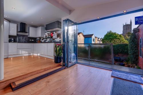 an open kitchen with a wooden floor and a large window at Bright Garden Flat, Private Sauna, Parking in Bristol