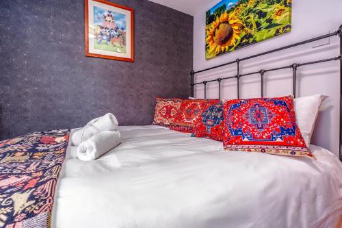 a bedroom with a white bed with colorful pillows at Bright Garden Flat, Private Sauna, Parking in Bristol