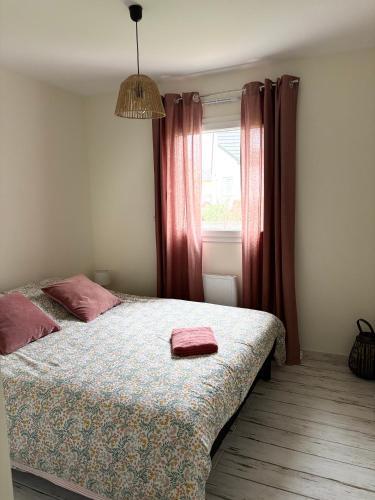 une chambre avec un lit et une fenêtre avec des rideaux rouges dans l'établissement La Tilloise, à Tilly-sur-Seulles