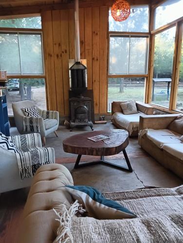 a living room with couches and a fire place at Refugio Silvestre Parque Nacional Siete Tazas-Salida a río y pesca in El Bolsico