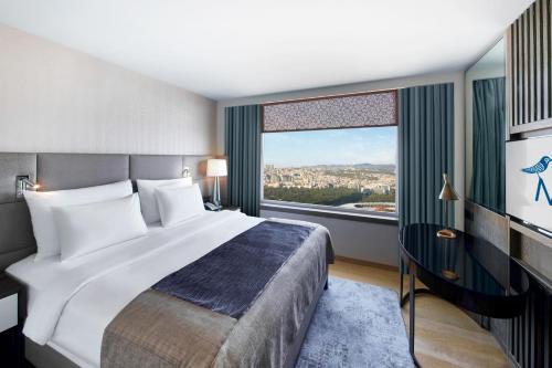 a bedroom with a large bed and a large window at The Marmara Taksim in Istanbul