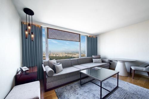 a living room with a couch and a table at The Marmara Taksim in Istanbul