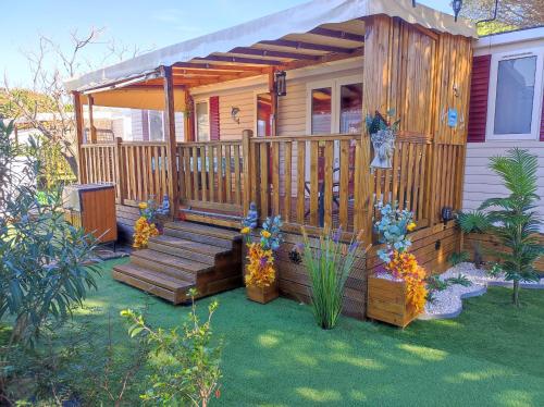 une maison avec une terrasse couverte en bois et une terrasse dans l'établissement MAR ESTANG, à Canet