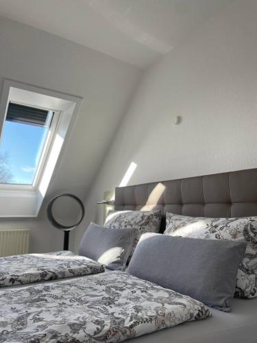 a bedroom with two beds with pillows and a window at Hotel Deichvoigt in Cuxhaven