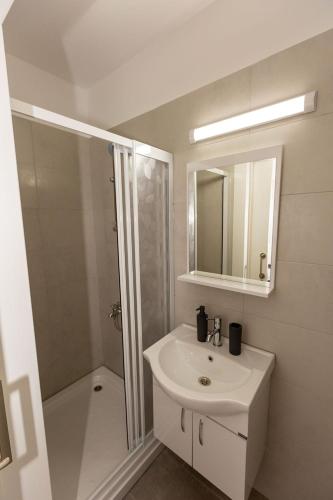 a white bathroom with a sink and a shower at Jasmine Gray by HolidayKeys in Kyrenia