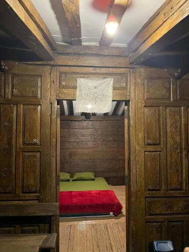 a small bed in a room with wooden cabinets at Sang Natha Lodge - Kopi Tiam & Agro in Tjatur