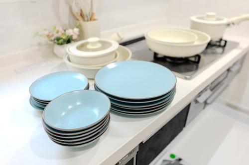four plates and bowls on a counter in a kitchen at Traveler's Home in Tokyo