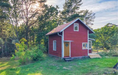 a small red house in the middle of a field at 1 Bedroom Cozy Home In Vikbolandet in Arkösund