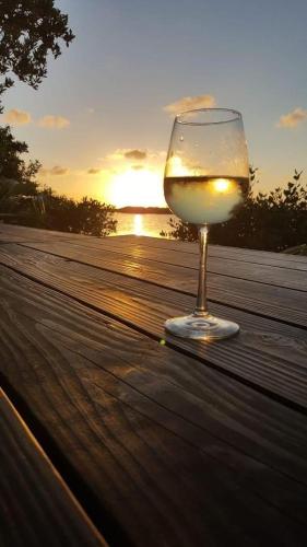 a glass of wine sitting on a table with the sunset at Maura's Holiday House in Silveira