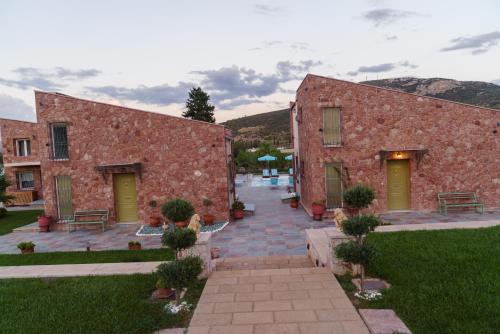 a brick building with green doors and a courtyard at 99 Luxury Exotic Villas in Nafplio