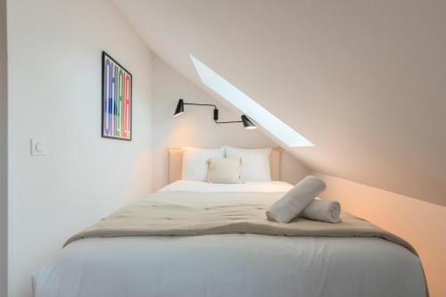 - une chambre blanche avec un lit mansardée dans l'établissement Studio sous les combles côté rue, parking gratuit, à Villeneuve d'Ascq