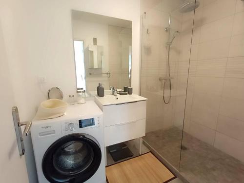 une salle de bain avec une machine à laver et un lavabo dans l'établissement Bel appartement avec parking WIFI au centre-ville de PERROS-GUIREC - Réf 938, à Perros-Guirec
