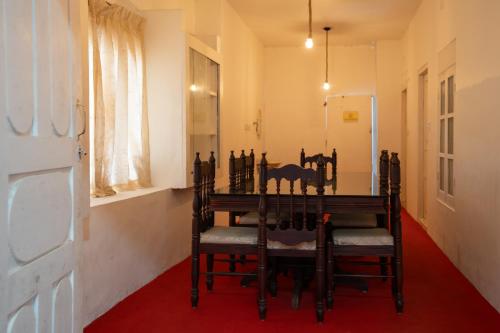 Casspo Forest Bungalow في Kallar Vattiyar: غرفة مع طاولة طعام مع كراسي