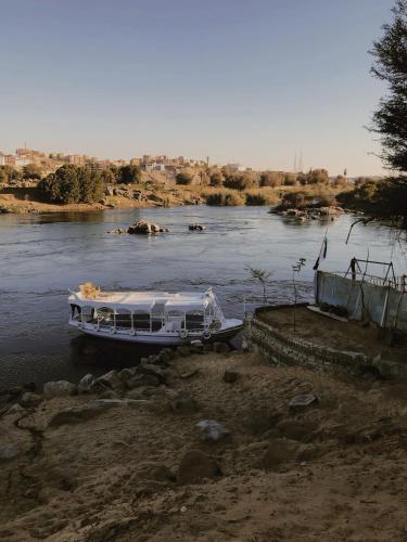 a boat is docked on a river at Anoosh camp in Aswan