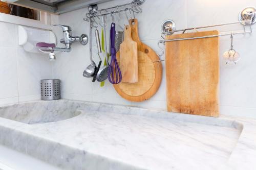 a kitchen counter with wooden utensils on the wall at Casa Europa - Arenzanohost in Arenzano