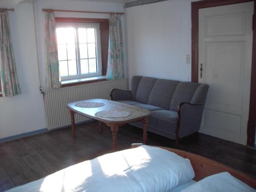a living room with a couch and a table at Astrupgaard Farm Holiday in Skærbæk