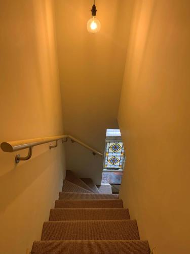 a staircase with a light on the wall and a window at Studio 4- 6 Norwich City Centre Apartment in Norwich