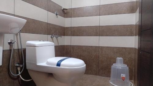 a bathroom with a toilet and a shower at Gateway Airport Hotel in Kannur