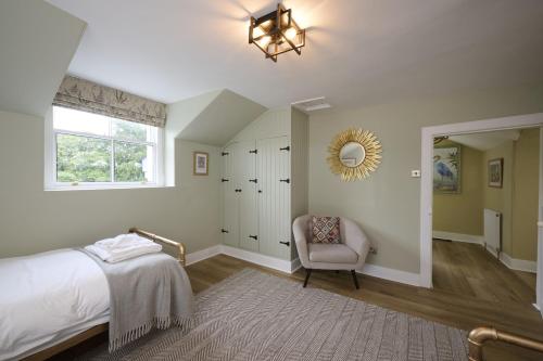 a bedroom with a bed and a chair and a window at Garden Cottage in Inverness