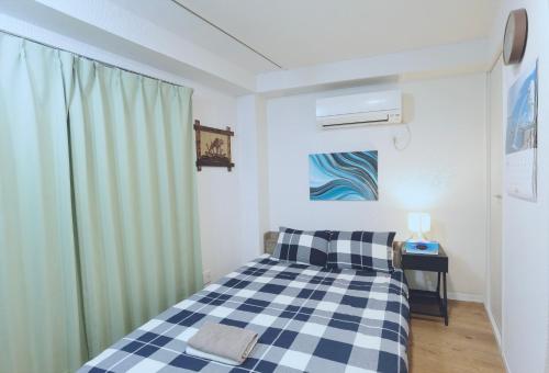 a bedroom with a bed with a checkered blanket at #201WZNET梅屋敷駅2分横浜羽田空港都心便利商店街1k静かな町 in Tokyo