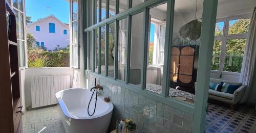 une salle de bain avec un lavabo et une fenêtre et des toilettes dans l'établissement Magnifique Villa 500 M Ocean 5 min du lac Hossegor, à Capbreton