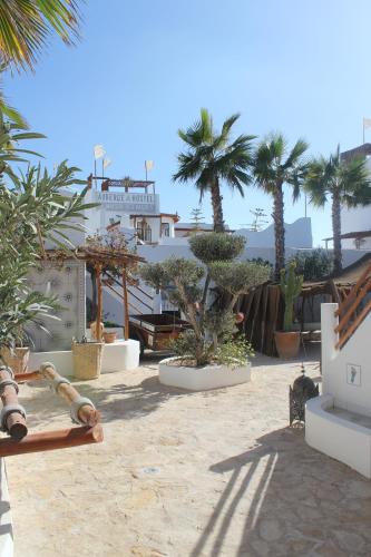 a resort yard with palm trees and a building at La Maison des Vagues in Sidi Kaouki